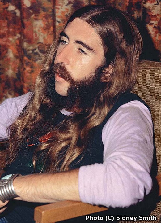 Berry Oakley seated, in a lavender shirt